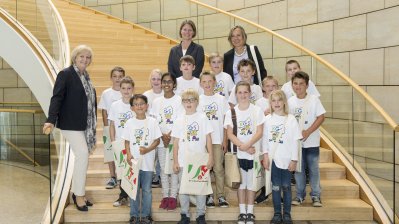 Ministerpräsidentin Hannelore Kraft und Schulklasse stehen auf einer Trepper im Landtag