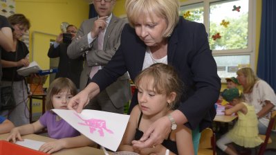 Ministerpräsidentin Hannelore Kraft bastelt mit Kindern am Tisch