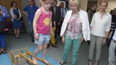Ministerpräsidentin Hannelore Kraft schaut einem Kind beim Balancieren zu