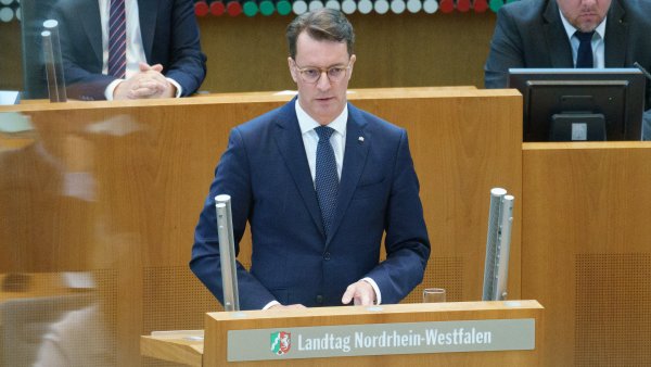 Ministerpräsident Hendrik Wüst steht am Rednerpult des Landtags Nordrhein-Westfalen und hält eine Rede