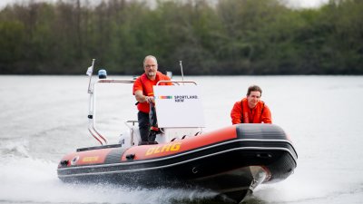 Zwei Männer fahren auf einem Schlauchboot des DLGR über Wasser