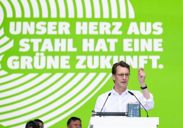 Ministerpräsident Hendrik Wüst hält eine Rede vor einer Wand mit dem Text "Unser Herz aus Stahl hat eine grüne Zukunft."